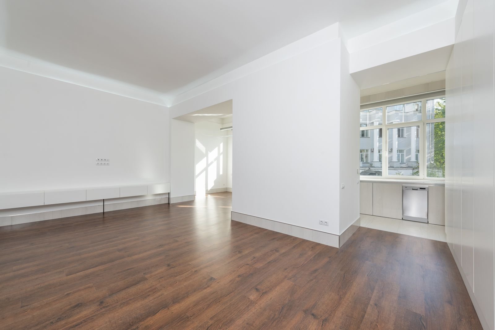 Empty bright apartment suite with wood flooring and large windows