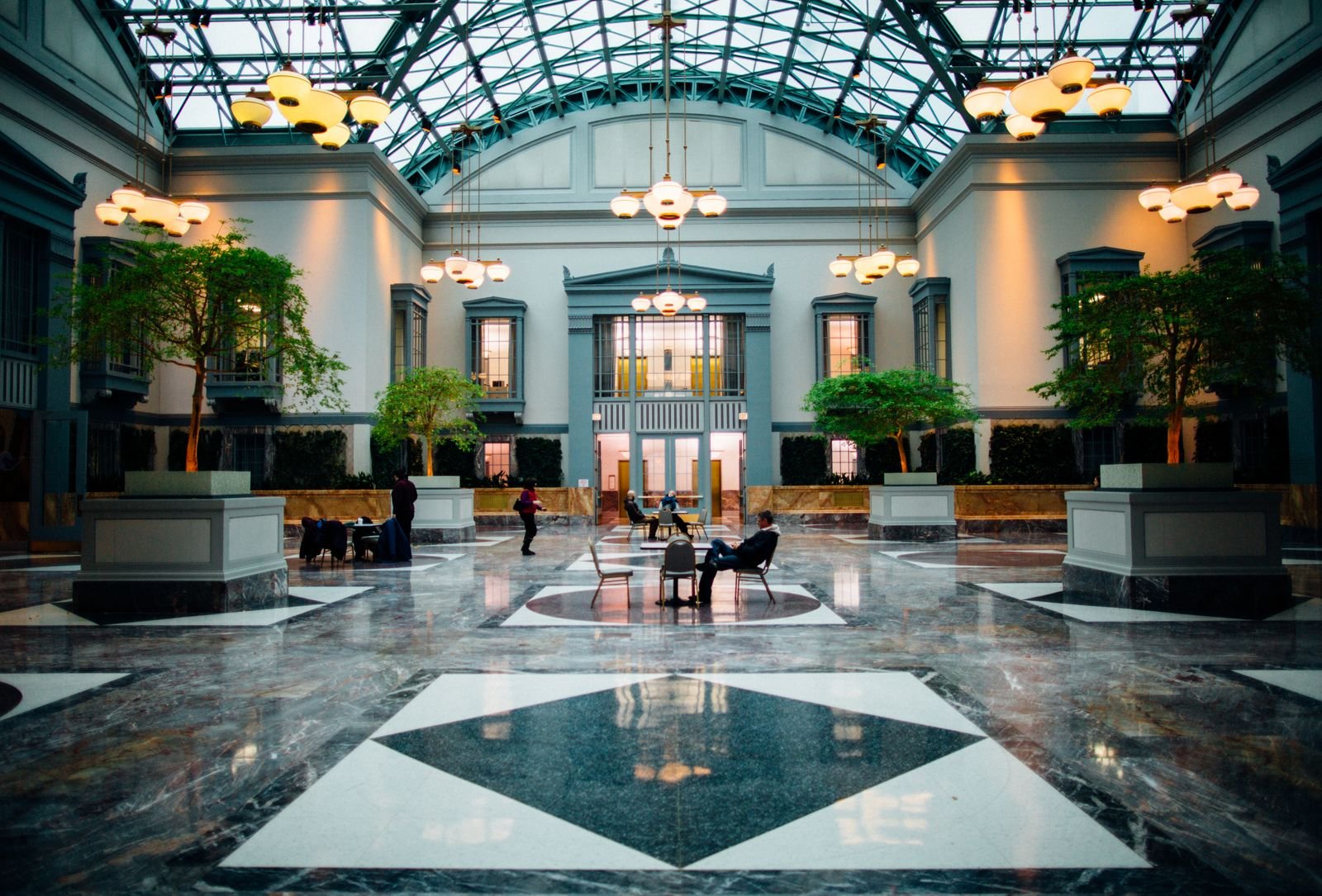 Grand hotel lobby atrium with a glass roof and marble floor