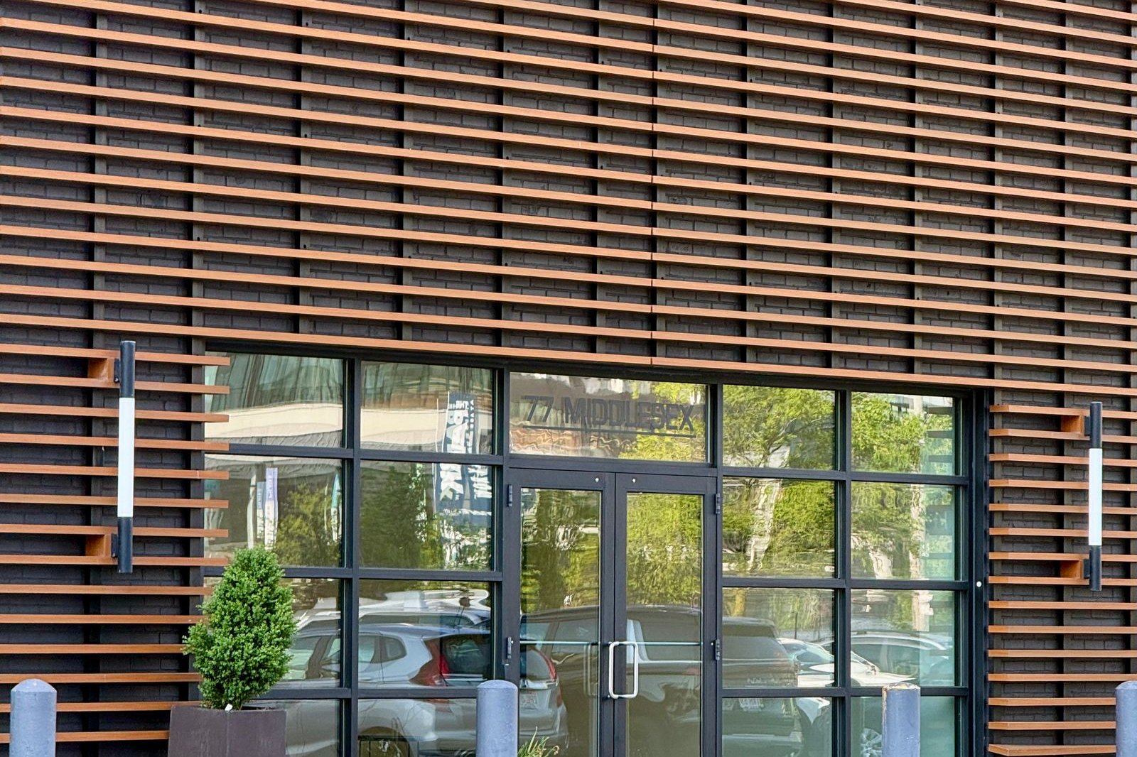 Glass-fronted commercial entrance clad in horizontal wood slats