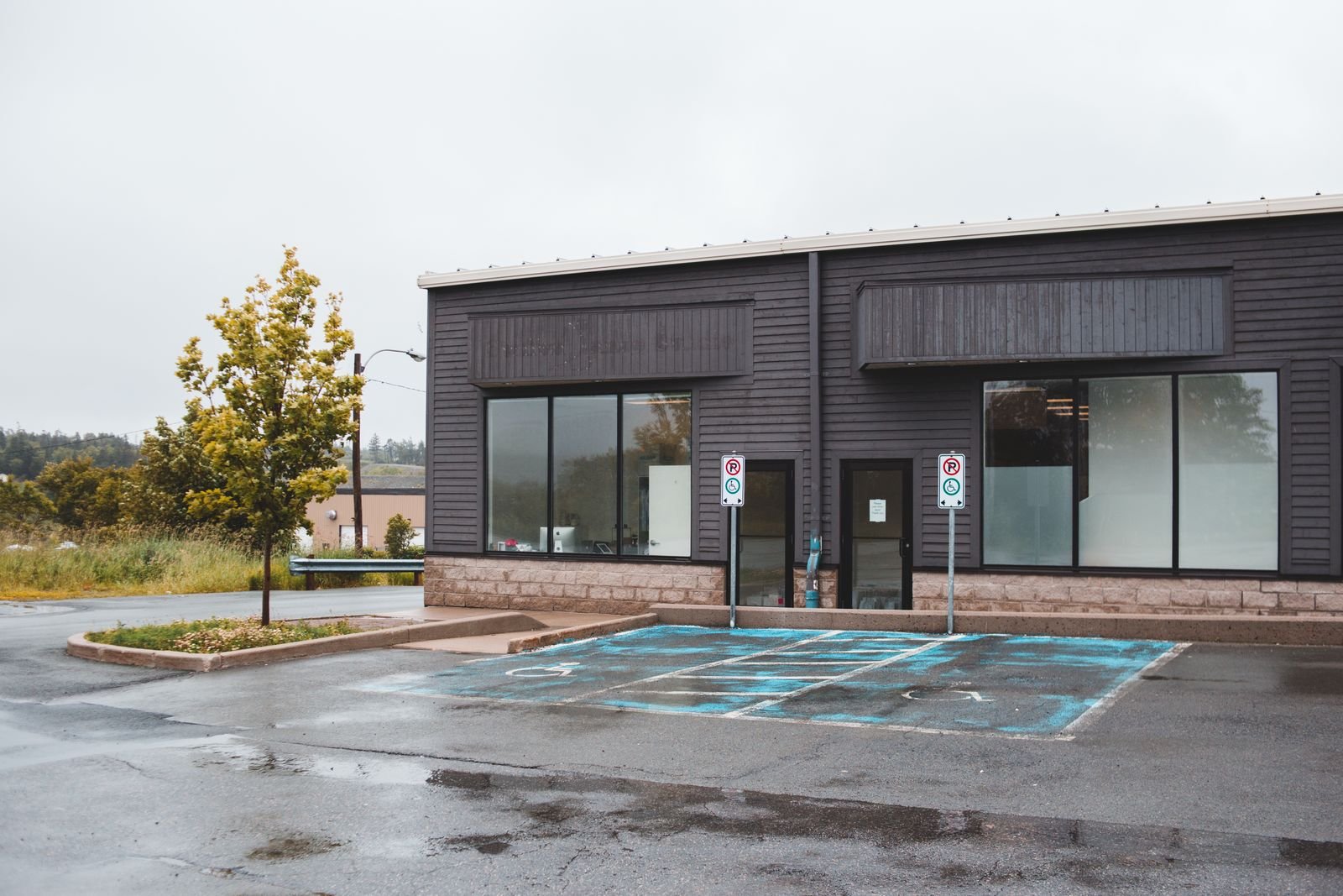 Single-storey dark-clad commercial building with a parking lot