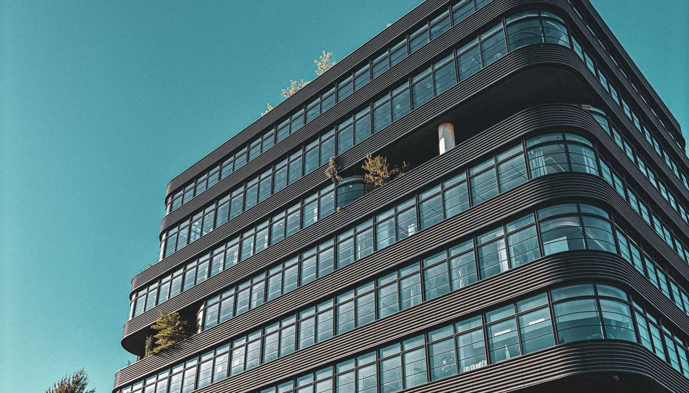 Modern glass office building against a blue sky