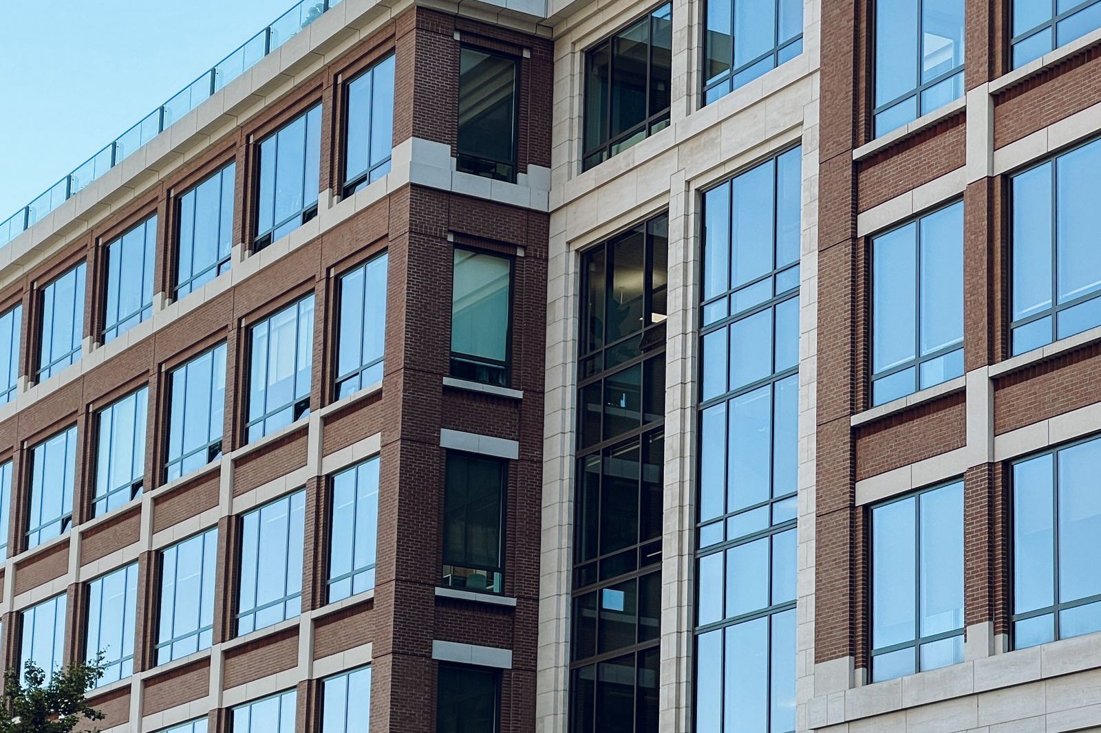Brick and glass mid-rise office building against a blue sky