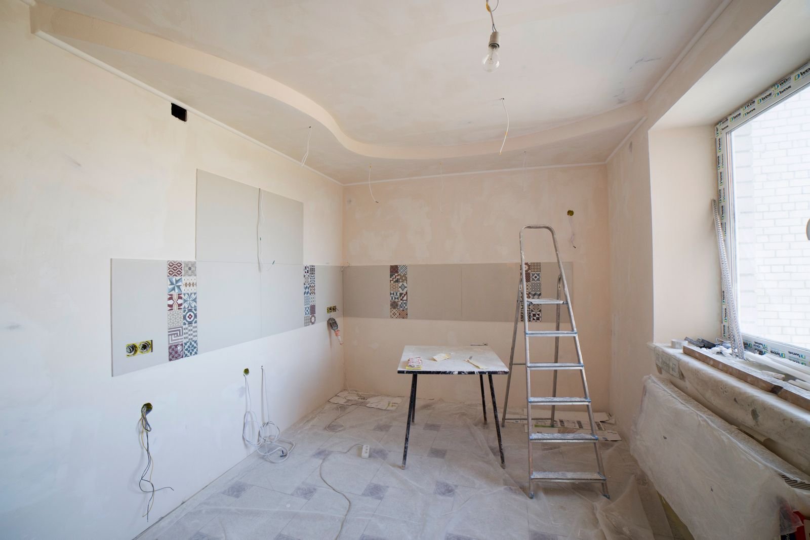 Apartment room under renovation with a ladder and unfinished walls