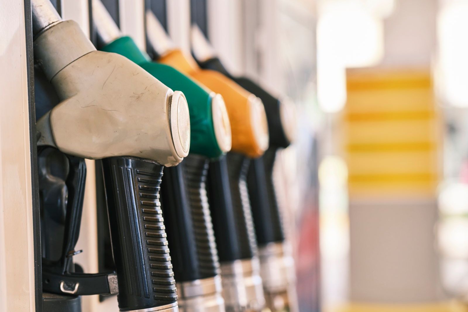 Row of colourful fuel pump nozzles at a gas station